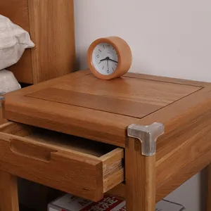 Transparent soft silicone corner protector for child safety installed on wooden nightstand