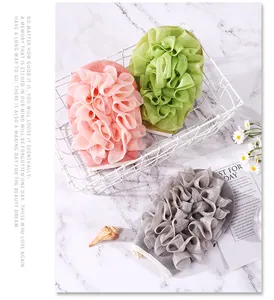 Weiche Peeling-Handschuhe in Rosa, Grün und Grau für eine sanfte Körperreinigung.
