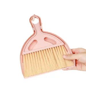 Roze mini veger en blik set voor bureau reiniging met een leuk vrolijk smiley ontwerp.