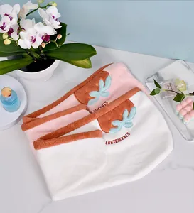 Détail de serviettes à cheveux en microfibre fraise avec de jolis motifs brodés.