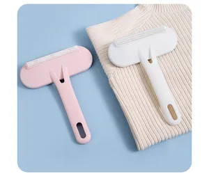 Close-up of double-sided lint removers in pink and white on a knit sweater background.