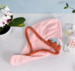 Gros plan d'un bonnet de séchage en polaire corail rose avec un motif de fraise