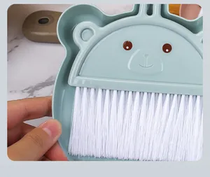 Primer plano de una mini escoba de escritorio con diseño de oso y cerdas blancas