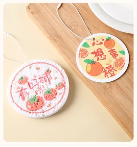 Detailed view of circular wood pulp cotton sponges with fruit designs and hanging loops