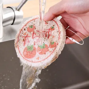Natural wood pulp cotton kitchen sponge with tomato pattern held under running water