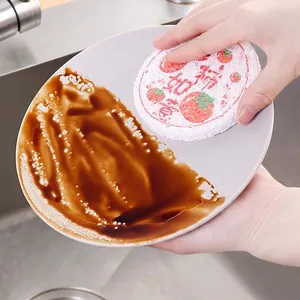 Eco-friendly natural wood pulp sponge effectively removing oil stains from a white ceramic plate