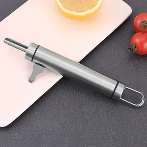 Detail of durable stainless steel macadamia nutcracker tool on a pink kitchen board