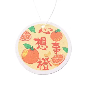 Round cellulose wood pulp kitchen sponge featuring orange pattern print and hanging loop