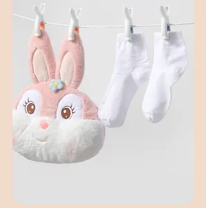 Heavy duty white plastic clothes peg securely holding a plush bag and socks on a line