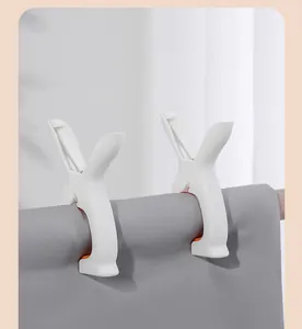 Large windproof white plastic quilt clothespins fixing a sheet on a drying pole