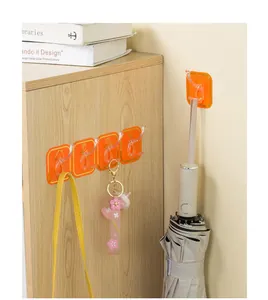 Orange self-adhesive row hooks on wooden cabinet showing bag and umbrella usage