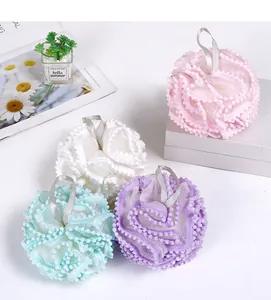 Detailed view of soft mesh bath loofahs in pastel pink, purple, white, and mint green