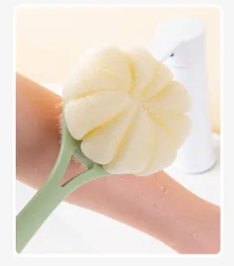 Close-up of long-handled bath brush with yellow mesh loofah used on skin