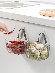 Cesti portaoggetti da parete trasparenti per aglio e peperoncino in cucina.