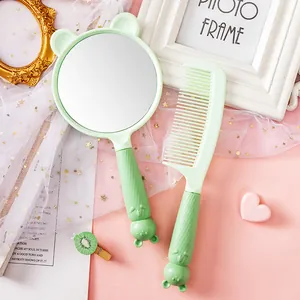Detailed view of cute mint green bear-themed handheld mirror and matching comb set.