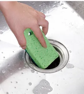 Vue détaillée d'une éponge en pâte de bois double face nettoyant un évier en inox
