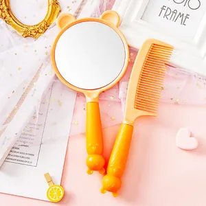 Close-up view of the cute yellow bear-themed hand mirror and matching hair comb set.