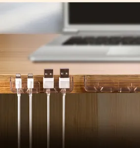 Dettaglio dell'organizzatore per cavi adesivo trasparente con fili USB sul tavolo
