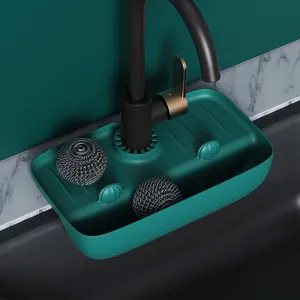 Detailed macro view of dark green silicone faucet drip mat with two steel scrubbers
