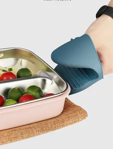 Close-up of blue silicone heat-resistant clip gripping a hot stainless metal food tray.