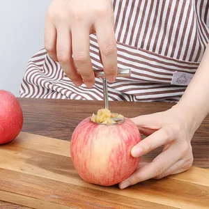 Professional stainless steel apple corer tool removing fruit core on wooden board