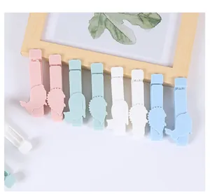 Primo piano di graziose clip di chiusura in plastica a forma di animali color pastello.