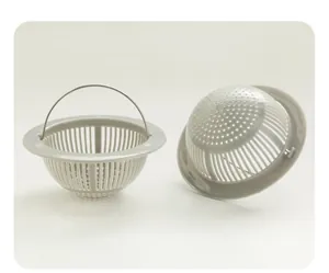 Detalle de coladores de fregadero de plástico gris con mango de metal para desagües.