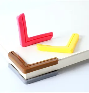 Detail showing colorful L-shaped corner protectors applied to white window frame or furniture