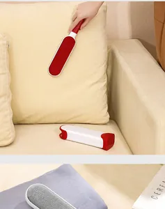 Close-up view of a static lint remover brush cleaning pet hair from a sofa cushion