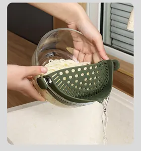 Detail of green silicone clip-on strainer draining water from a bowl of noodles
