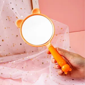 Cute orange cartoon handheld makeup mirror with bear ears for portable vanity use