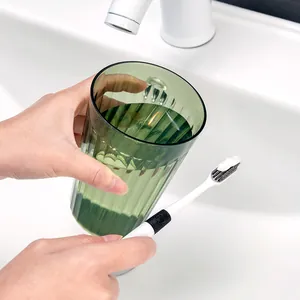 Minimalistischer dunkelgrüner PET-Mundspülbecher und Zahnbürste im Badezimmer