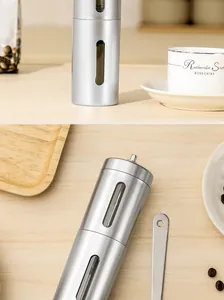 Detail of a portable stainless steel manual coffee grinder with visible bean window