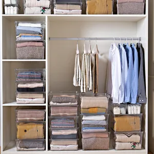 Clear plastic storage boxes organizing various clothes in a modern white wardrobe closet
