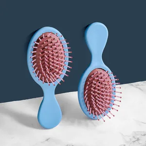 Mini spazzola massaggiante portatile azzurra con setole rosa per capelli da viaggio