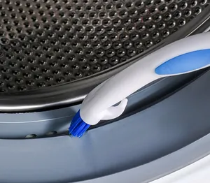 Gros plan d'une brosse nettoyant le joint en caoutchouc d'une machine à laver.