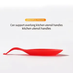Heat resistant red silicone spoon rest with a graceful curved tail for kitchen utensils