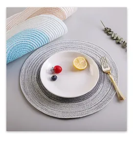 Detailed shot of a grey gradient woven placemat with fruit on a white ceramic plate