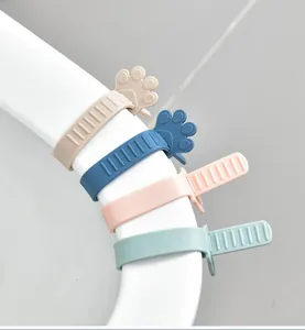 Detail van siliconen kattenpoot toiletbrillifters in vier pastelkleuren op een rand
