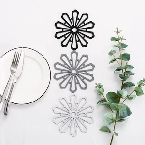 Set di 3 tovagliette in silicone a forma di fiore resistenti al calore in nero e grigio.