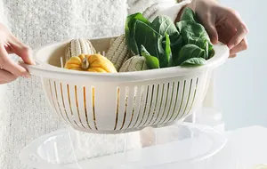 Detail of double-layer plastic drain basket filtering water with fresh vegetables.