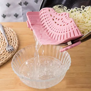 Functional pink silicone snap-on pot strainer draining water from noodles into a glass bowl
