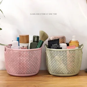 Set of two woven plastic desktop storage baskets in pink and green for cosmetics