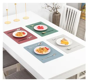 Set di tovagliette in pelle stile nordico in vari colori su tavolo da pranzo bianco