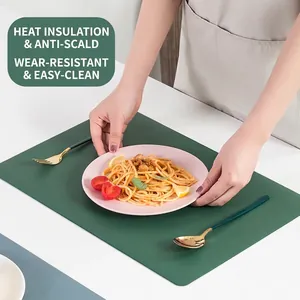 Tovaglietta nordica in pelle verde scuro testurizzata su tavolo bianco con pasta