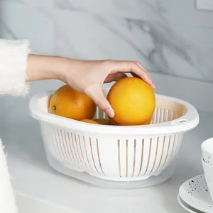 Modern white double-layer kitchen drain basket shown with fresh oranges on a marble top