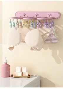 Wall-mounted foldable pink drying rack for socks and underwear in a home setting.