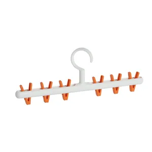 Space-saving white plastic hanger with six orange clips for drying socks and underwear