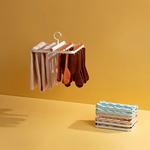 Multi-clip plastic clothes hanger for drying socks and towels in warm yellow setting