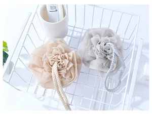 Detailed view of two thickened rose-shaped bath sponges in nude and light grey